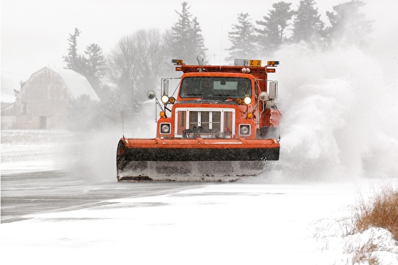 Snow plow driving through snow