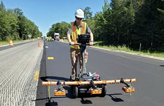 Man using machine to print centerpoints on to road