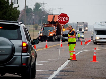 Flagger holding a stop sign in a roadway work zone